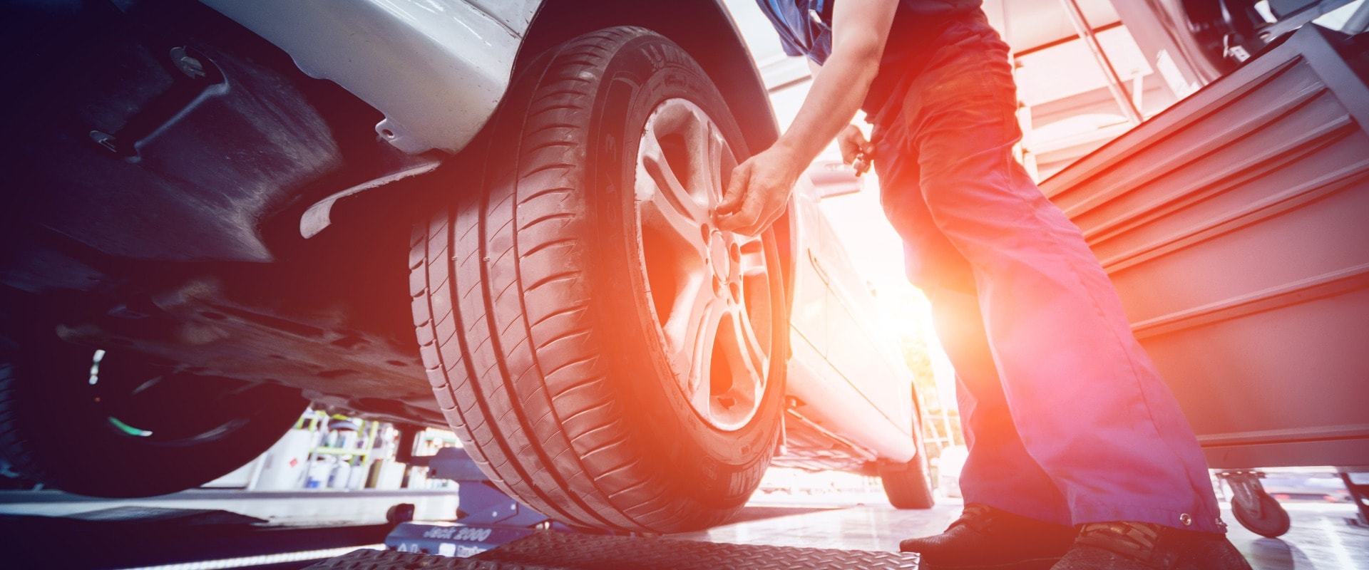 Automechaniker prüft Autoreifen